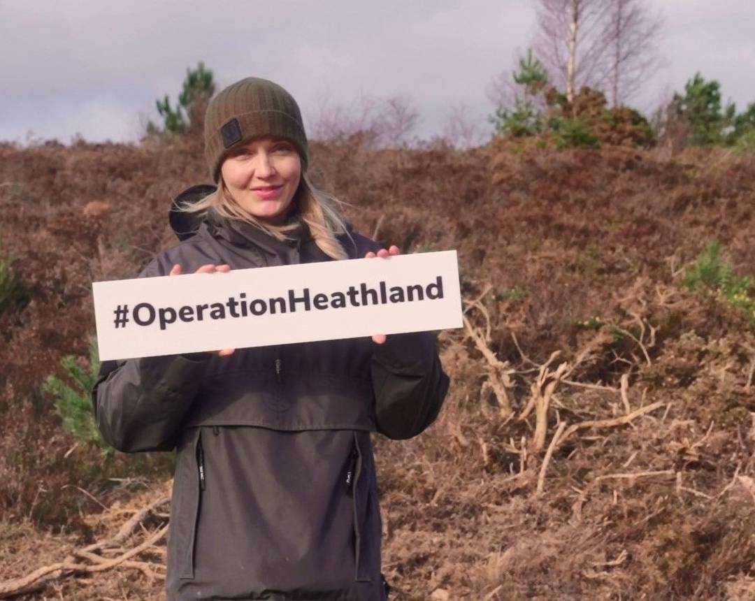 Victoria Pendleton holding an Operation Heathland hashtag